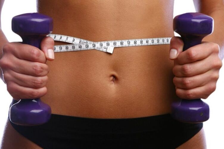 Fit bir kızın ellerinde fitness dambıl